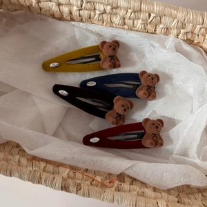 Detail von vier beflockten Bären-Haarspangen in Gelb, Blau und Rot mit Love-Gravur