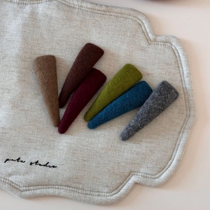 Detailed close-up of colorful felt fabric hair clips set on linen fabric background