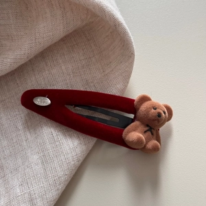 Detail einer roten Samt-Haarklammer mit beflocktem Bären und Love-Metall-Anhänger