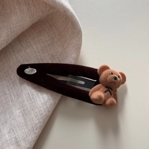 Nahaufnahme der Samt-Bären-Haarspange mit brauner Beflockung und silberner Love-Plakette