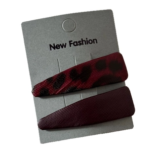 Chic leopard print and deep red faux leather BB hair clips on a grey display card