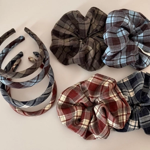 Close-up of handmade plaid scrunchies and headbands in autumn colors and wool fabric