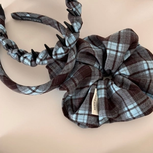 Detail of blue and brown checkered headband and hair scrunchie with handmade labels