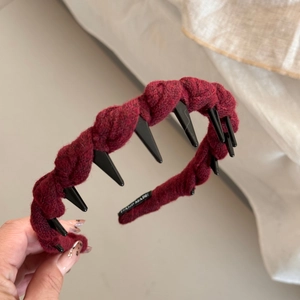Vue détaillée du serre-tête torsadé en tricot rouge bordeaux avec étiquette Hand Made