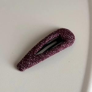Detail shot of deep purple tweed fabric texture on a high-end metal hair claw clip