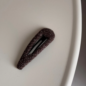 Detail of Korean brown tweed fabric hair clip with a refined minimalist woven texture