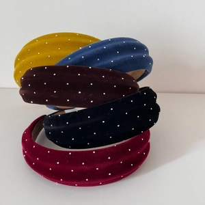 Close-up of velvet padded headbands with silver studs in five assorted colors
