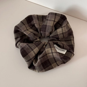 Detailed view of large brown plaid scrunchie with soft fabric texture and Korean woven label
