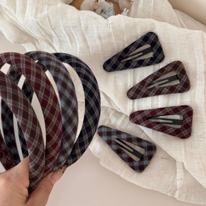 Detail view of Scottish plaid fabric covering the triangle snap hair clips and headbands