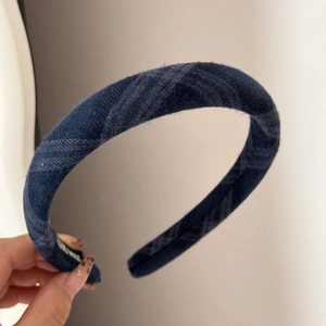 Close-up of thick navy blue plaid headband showing fabric texture and handmade label