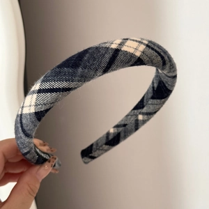 Macro detail of thick navy blue and beige plaid fabric scrunchie with soft texture