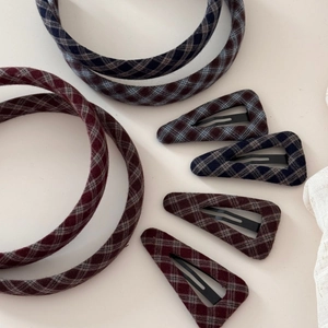 Detail view of navy blue and wine red plaid fabric headbands and triangular hair clips