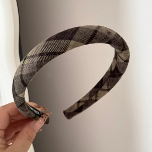Detail of brown plaid scrunchie with handmade label and soft wool-like texture