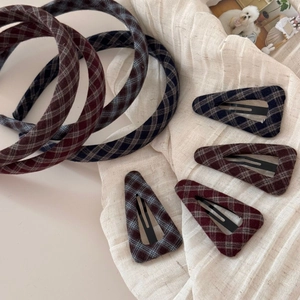 Close-up of vintage dark plaid wool geometric hair clips and headbands set