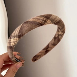 Detail of vintage brown tartan fabric headband with soft textured wool material