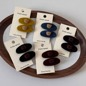 Close-up of velvet oval hair clips with cute flocked bear motifs on a display card