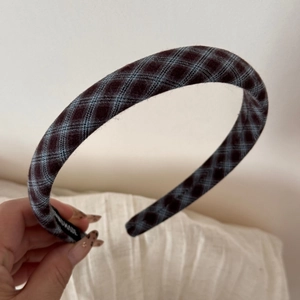 Detail of handmade vintage plaid hair clip with close-up of the internal label