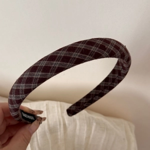 Close-up of handmade dark plaid wool geometric hair clip with vintage British style