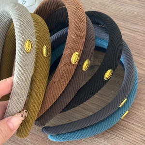Classic corduroy headbands with oval gold labels in grey, yellow, and blue colors