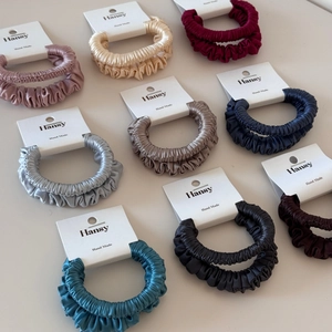Detail showing smooth satin silk hair ties in nine elegant colors with elastic pleats