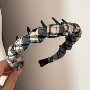 Detail of brown plaid fabric headband with black plastic inner teeth for secure hair grip