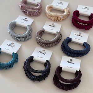 Collection of satin silk scrunchies in nine colors with elegant handmade brand tags