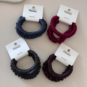 Detail view of premium satin scrunchie sets in navy, burgundy, black, and brown