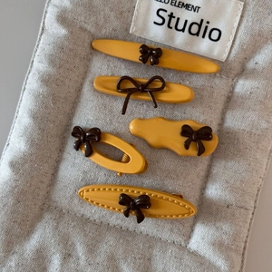 Five-piece yellow hair clip set with brown bows in various geometric shapes for women
