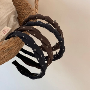 Close-up of brown and navy polka dot fabric headbands with non-slip inner teeth detail