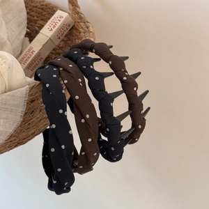 Braided fabric headbands with white polka dots and brown design on a woven basket