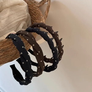 Close-up of four retro twisted headbands in navy polka dots and solid brown fabric