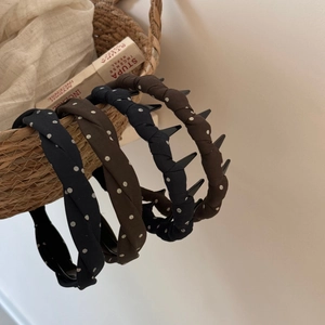 Detail view of polka dot headbands in dark blue and brown with non-slip inner teeth
