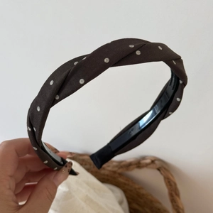 Detail view of brown polka dot headband with anti-slip inner grip and twist knot design