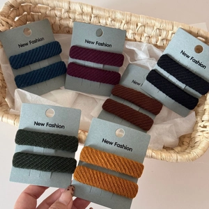 Detailed view of six colors of twill fabric sponge hair clips on display cards