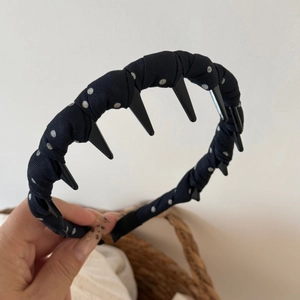 Detail of black polka dot headband showing internal plastic teeth for secure hair grip