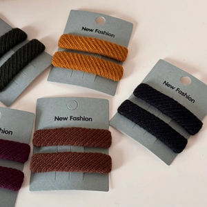 Macro detail of twill fabric texture on rectangular hair clips in various autumn colors