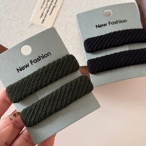Detail of fabric twill sponge hair clips in dark green and black on fashion card