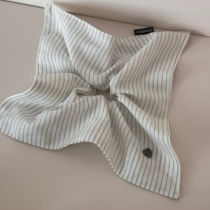Detail of white striped scrunchie with handmade tag and heart button ornament