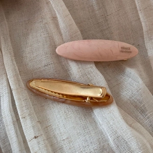 Close-up of acetate hair clips with marble texture and gold metal spring mechanism