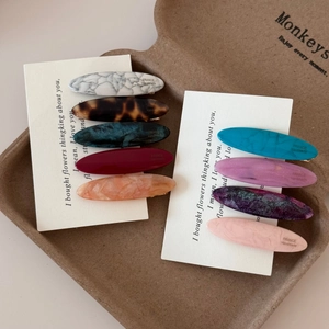 Detailed set of acetate hair clips showing marble patterns and handmade logo engravings