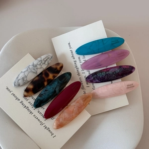 Detailed set of eight oval acetate hair clips in assorted marble and tortoiseshell patterns