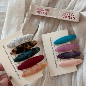 Detailed macro view of acetate oval hair clips set featuring vintage marble and leopard patterns