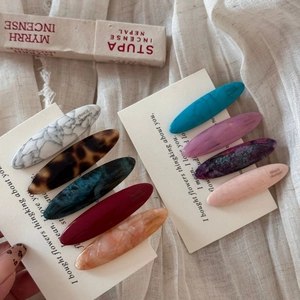 Macro shot of colorful acetate hair clips with marble textures on a display card