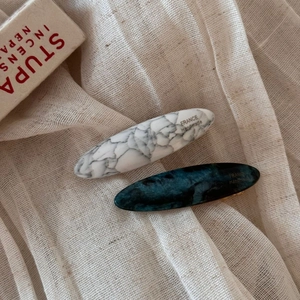 Detail of acetate marble oval hair clips in white and teal with gold handmade lettering