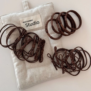 Detailed set of leopard print hair ties and bows with a branded cotton storage bag