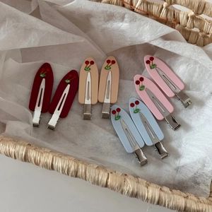Detail of matte acrylic hair clips with cherry rhinestone designs in various pastel colors