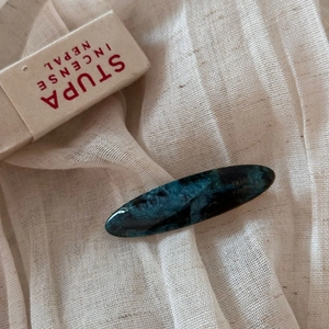 Detail of blue marble acetate hair clip with gold France Handmade logo on linen background