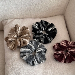 Détails de quatre chouchous tricotés à rayures, texture laineuse douce et étiquettes fashion