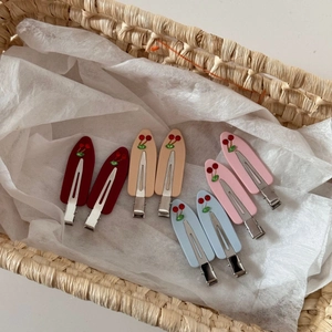 Close-up of acetic acid cherry hair clips in red, apricot, pink, and sky blue colors