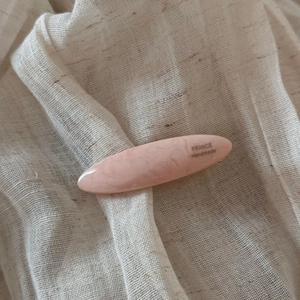 Detail of pink marble acetate hair clip featuring FRANCE Handmade gold lettering